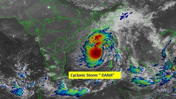 Cyclone Dana impact in Odisha with heavy winds and rain, people being relocated to safer places.