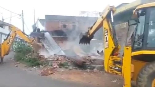सूरजपुर में प्रधान आरक्षक की पत्नी और बेटी की हत्या के मामले में प्रशासन द्वारा मुख्य आरोपी कुलदीप साहू के अवैध निर्माणों पर बुलडोजर चलता हुआ।