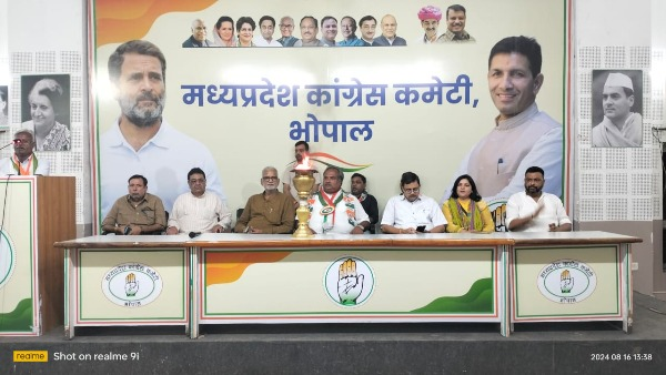 "राजीव गांधी ज्योति संदेश यात्रा के मध्य प्रदेश आगमन पर कांग्रेस कार्यालय में आयोजित स्वागत समारोह का दृश्य, जिसमें कांग्रेस नेता हाथ में मशाल लिए खड़े हैं।"