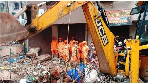 "Three-story building collapses in Navi Mumbai, trapping residents under debris. Rescue operations are ongoing with two people hospitalized in stable condition. The 10-year-old building may face legal action after investigation."